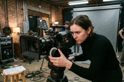 Étudiante en école de cinéma réglant une caméra professionnelle dans un studio de tournage